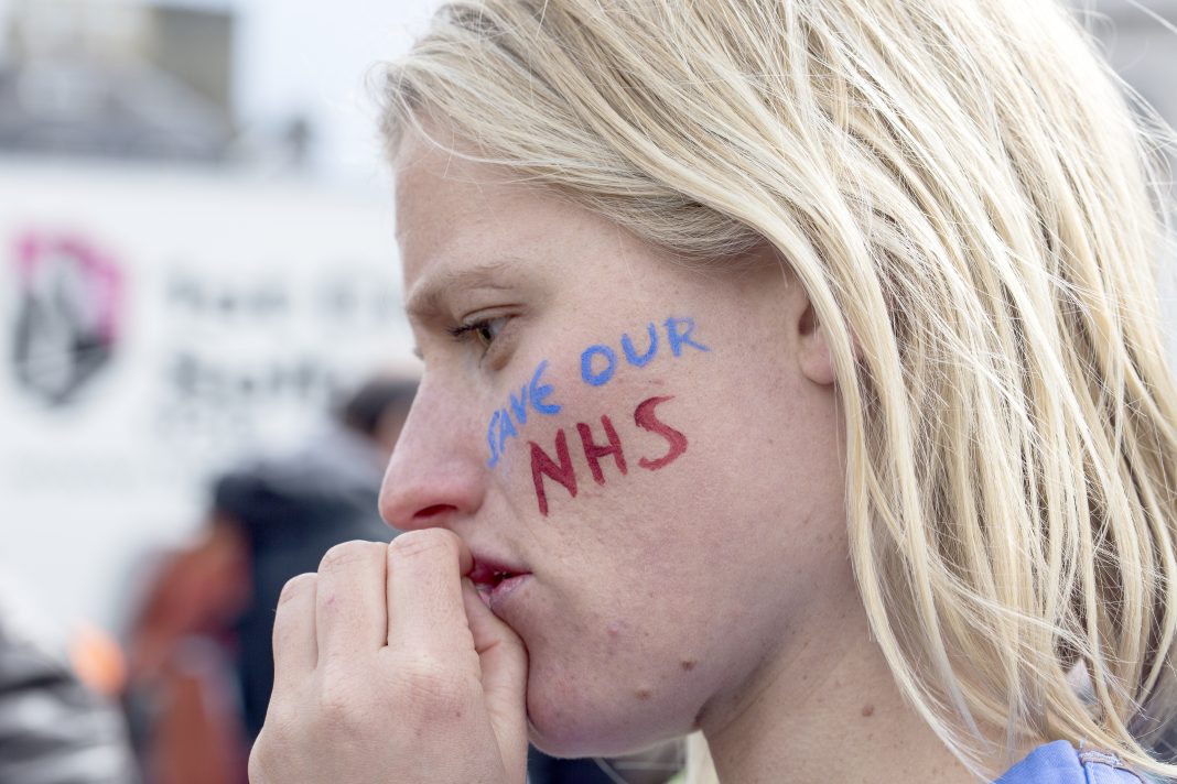 London, United Kingdom - April 16, 2016: A junior doctor at the anti-austerity march in London, contemplates the speeches being made in Trafalgar Square.