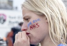 London, United Kingdom - April 16, 2016: A junior doctor at the anti-austerity march in London, contemplates the speeches being made in Trafalgar Square.