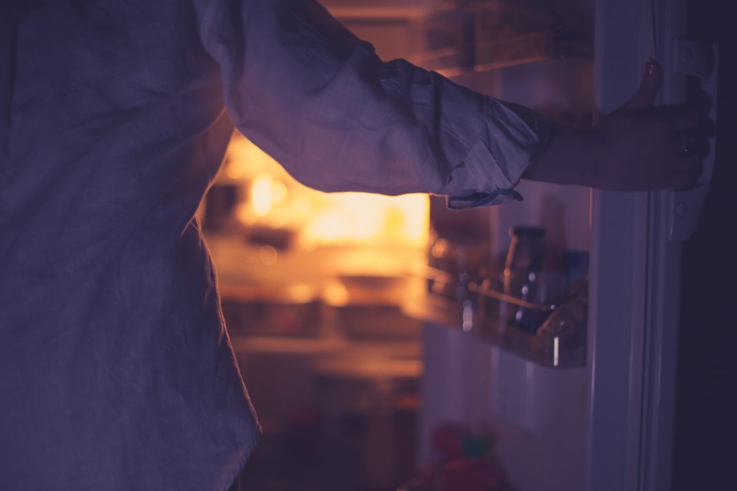 person opening fridge at night to symbolise eating disorder
