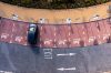 An aerial view directly above an electric vehicle charging station with electric car charging in a parking space