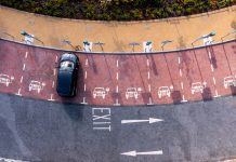 An aerial view directly above an electric vehicle charging station with electric car charging in a parking space