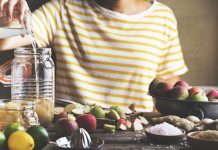 Making homemade apple cider vinegar, preparation process. Woman pouring water in jar