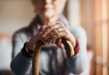 Cropped shot of a senior woman holding a cane in a retirement home