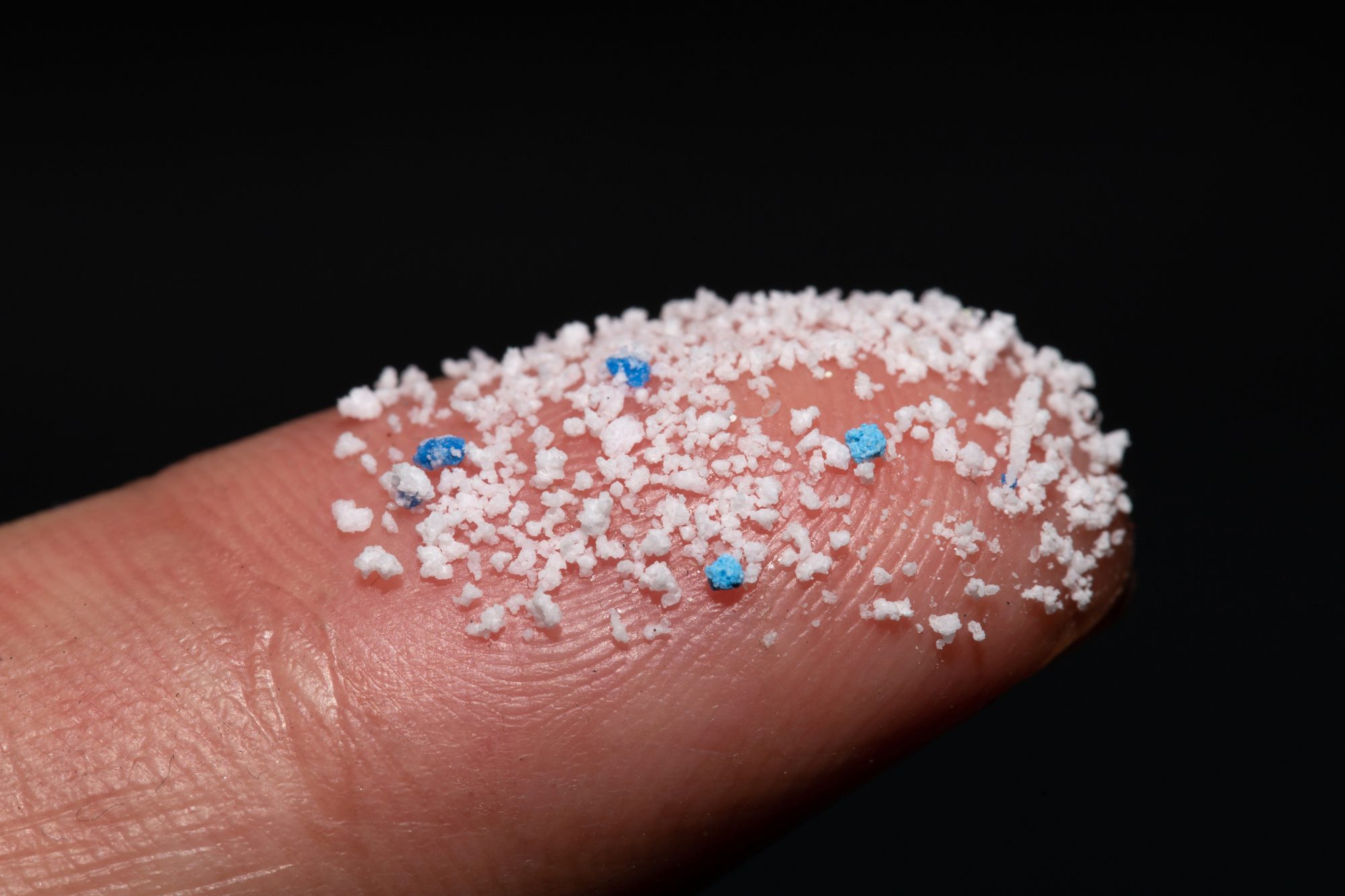 Small Plastic pellets on the finger. Micro plastics