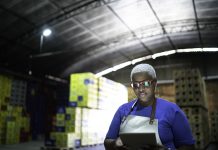 Serious employee using digital tablet at warehouse