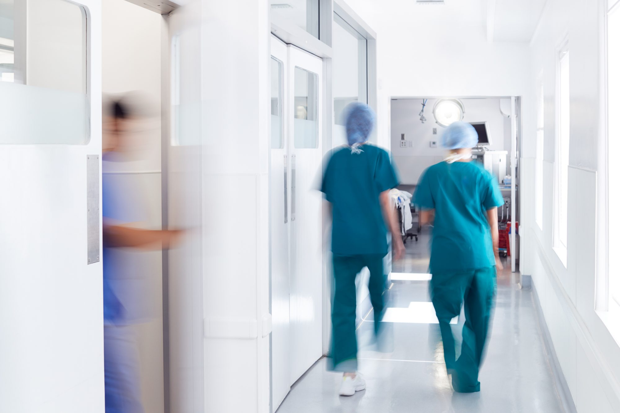 Professional surgeons in uniform and VR headset performing operation on patient in modern clinic.