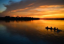 A small motorized canoe on the Guaporé - Itenez river during sunset, Ricardo Franco village, Vale do Guaporé Indigenous Land, Rondonia, Brazil, on the border with Bolivia