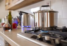 Close-up side-view shot of a cooking pot on a gas stove. Using a single ring to save extra cost of using gas as current energy prices increase.