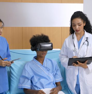 Doctor is going to visit patient with VR headset at hospital room.