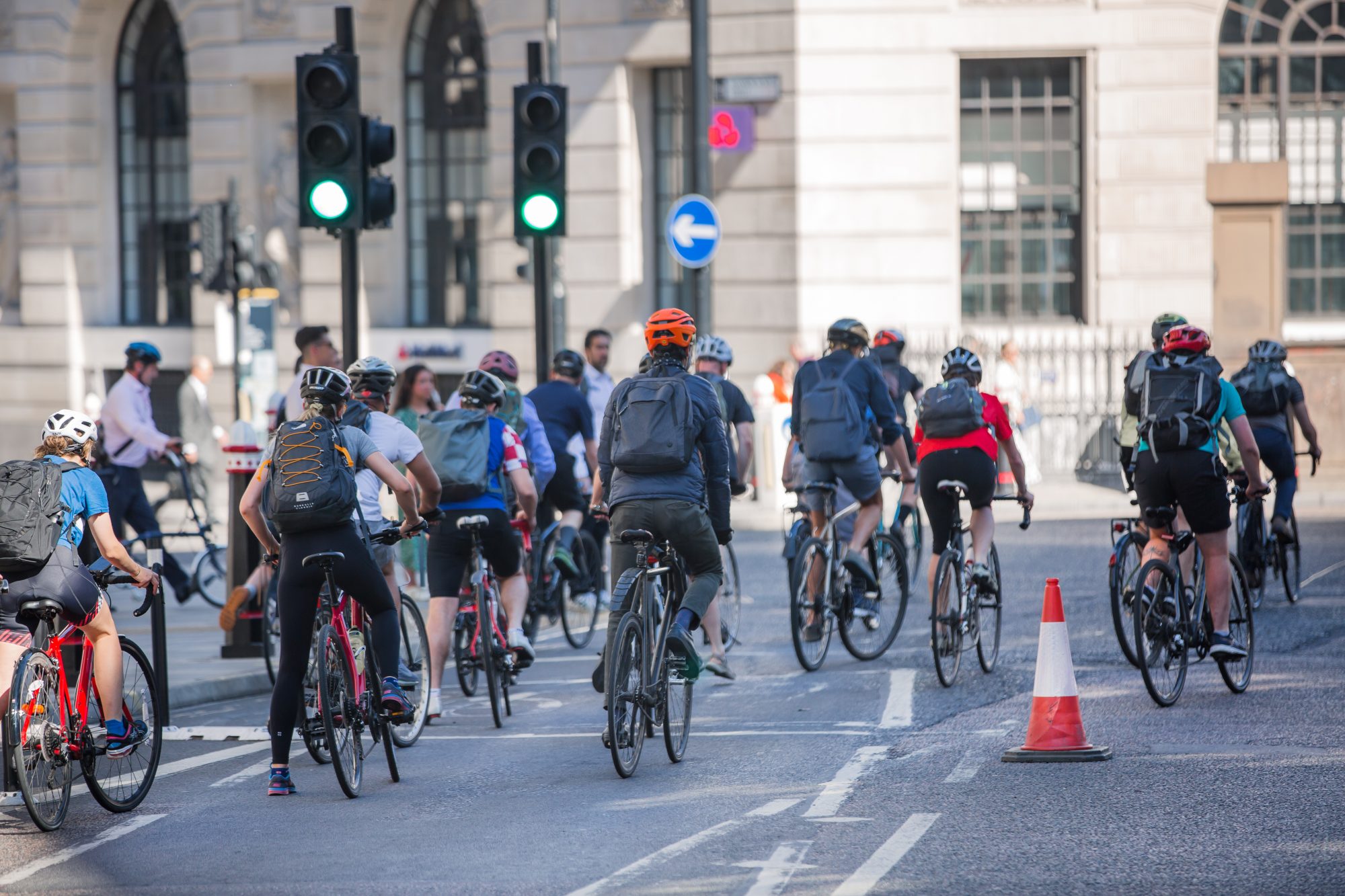 People cycling at work by bike and make a spot by the traffic lights. People cycling into the City of London