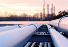 steel long pipe system in crude oil factory during sunset, Alaskan setting, oil pipe signifying the Willow project