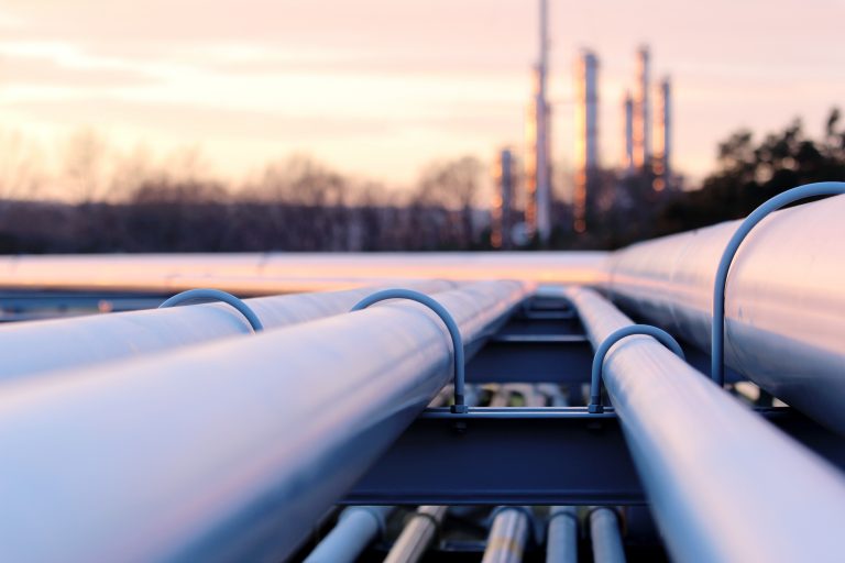 steel long pipe system in crude oil factory during sunset, Alaskan setting, oil pipe signifying the Willow project