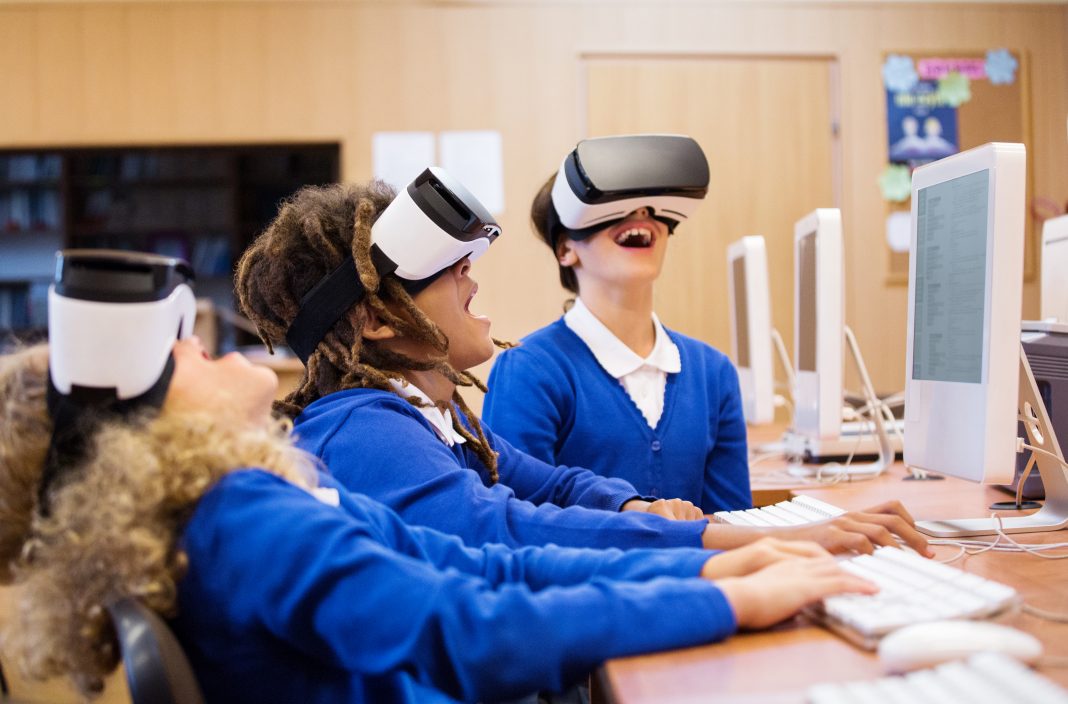 girls using VR headsets in computer lab at school