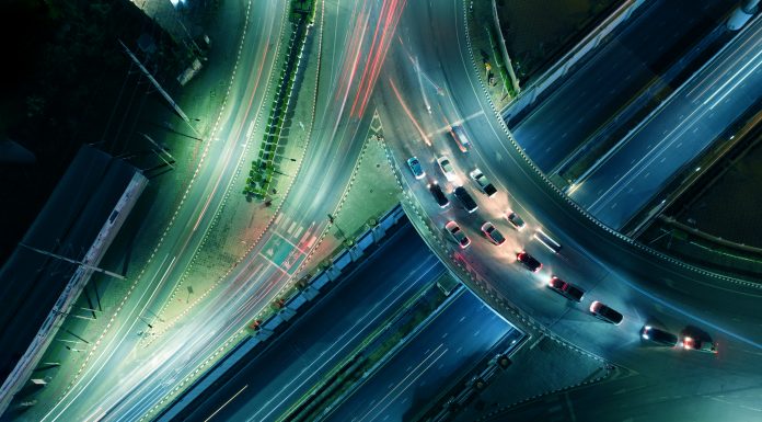 Expressway top view, Road traffic an important infrastructure, car traffic transportation above intersection road in city night, aerial view cityscape of advanced innovation, financial technology