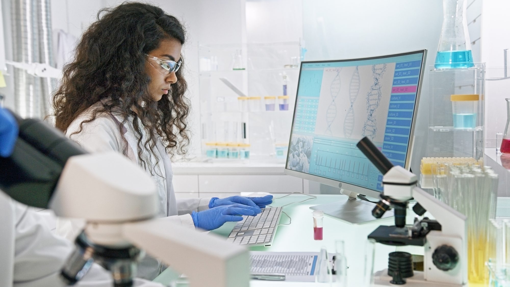 Multi ethnic laboratory team at work. Senior doctor using microscope.