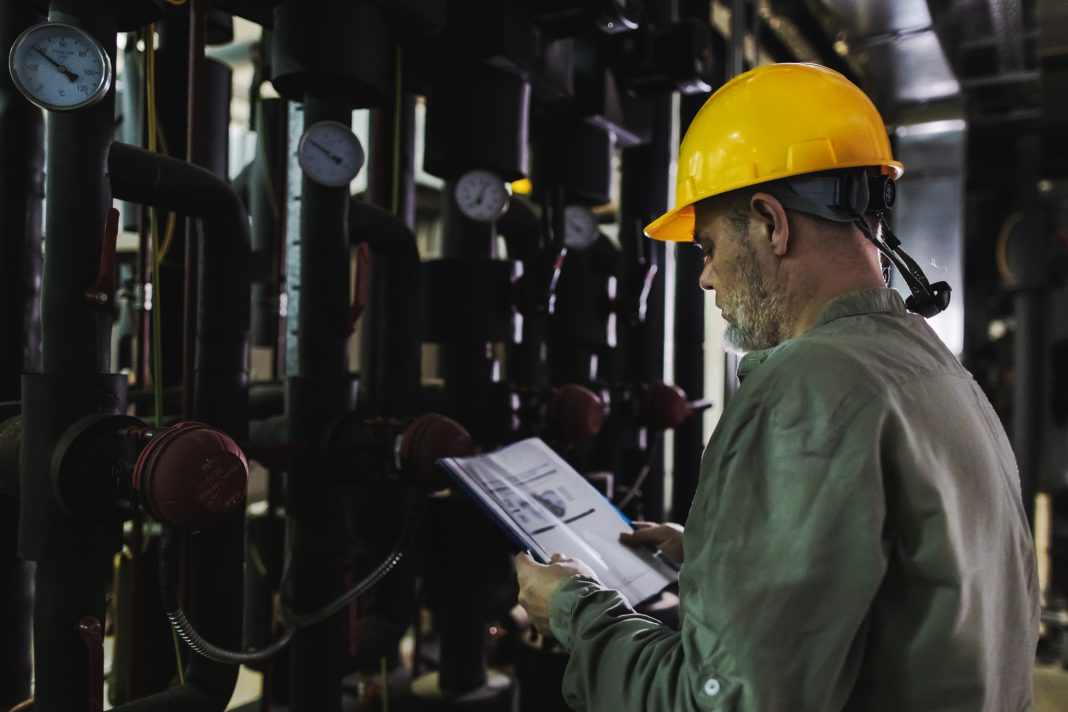 Engineer working on computer to maintain heating and cooling sistems