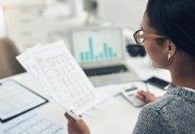 Closeup shot of an unrecognisable businesswoman calculating finances in an office