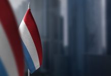 Small flags of Luxembourg on a blurry background of the city