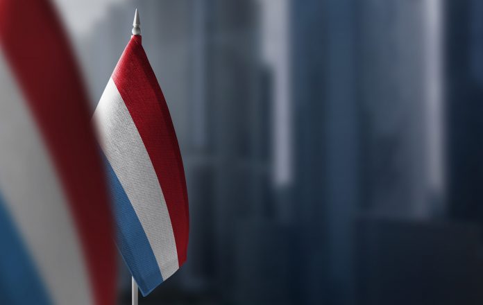 Small flags of Luxembourg on a blurry background of the city