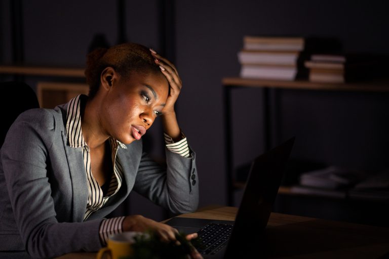 A tired female secretary working late at night