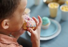 Little boy eating delicious donut