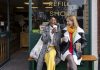 Two friends sitting outside a store that promotes sustainable living in the North East of England. The store has refill stations to reduce plastic and food waste. The store sells homemade organic bars of soap as well as vegan based foods.