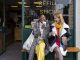 Two friends sitting outside a store that promotes sustainable living in the North East of England. The store has refill stations to reduce plastic and food waste. The store sells homemade organic bars of soap as well as vegan based foods.