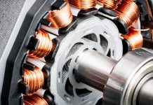 Detail of copper winding, stack and shaft of a electric permeant magnet motor for home appliances. Selective focus and white background.