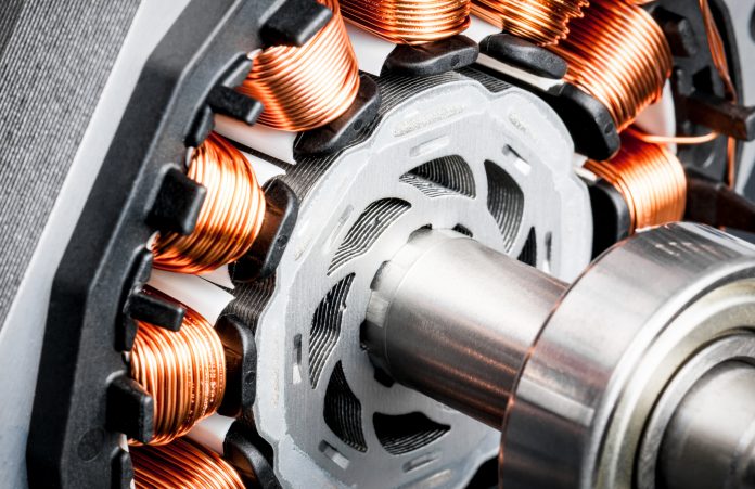 Detail of copper winding, stack and shaft of a electric permeant magnet motor for home appliances. Selective focus and white background.