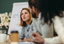 Young businesswoman having a discussion with her colleagues in a boardroom. Creative young businesswoman sharing her ideas during a meeting in a modern office.