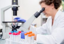 Female Researcher Examining Scientific Sample Under a Professional Microscope