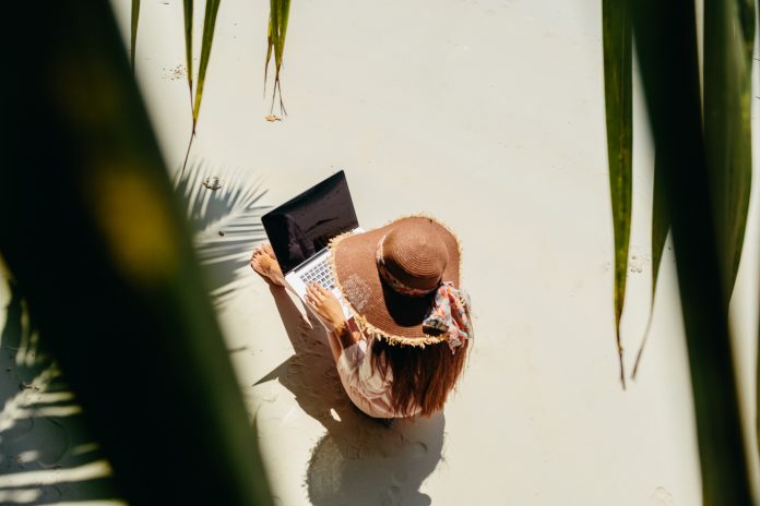 Woman freelancer on the beach in tropics