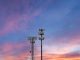 Two towers providing cellular broadband and data service to rural areas against the sunset. Illustrates digital divide.