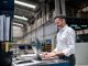 Mature businessman using laptop in a factory