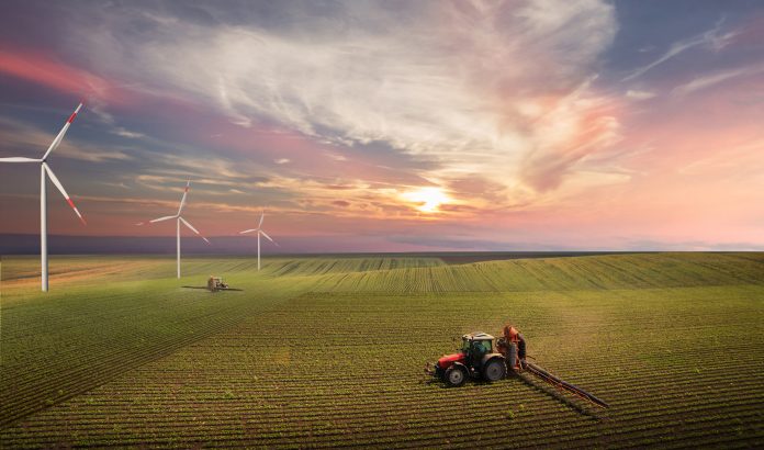 Tractor spraying pesticides on soy field with sprayer at spring