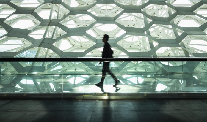 Man walking alone in modern corridor hallway. life