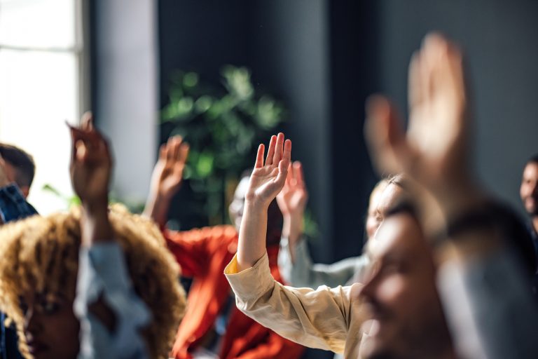 Group of Anonymous People Raising Hands on a Seminar