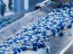 Blue Capsules on Conveyor at Modern Pharmaceutical Factory. Tablet and Capsule Manufacturing Process. Close-up Shot of Medical Drug Production Line.