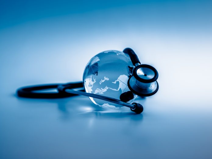 Global healthcare. Globe and stethoscope, studio shot.blue toned images.