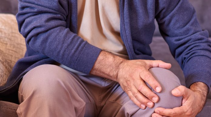 A selective of male hands holding a knee because of osteoarthritis, arthritis, and rheumatism
