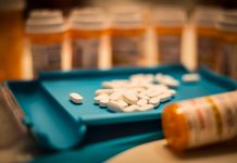 Unsorted prescription pills sit in a pharmacist's counting tray before they are bottled, opioid use