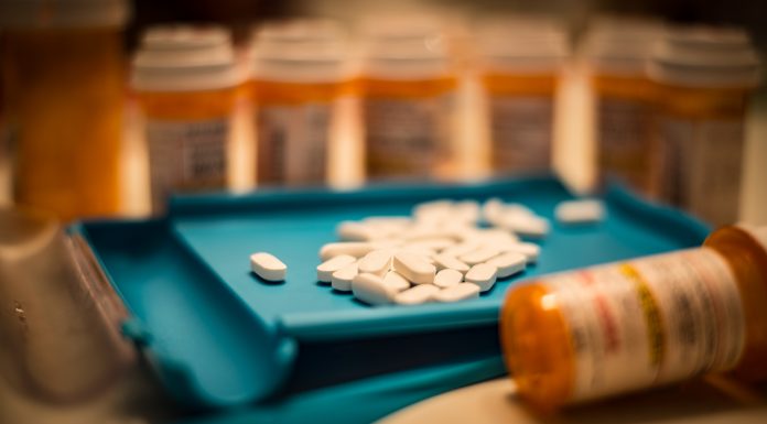 Unsorted prescription pills sit in a pharmacist's counting tray before they are bottled, opioid use