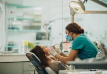 Female dentist examining young woman's teeth.