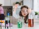 Child playing making some experiments , while her mother working in the kitchen