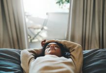 Cropped shot of a young woman lying on her bed with her eyes closed