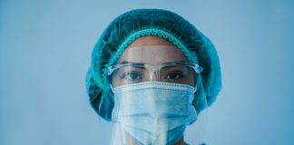 Portrait of young female nurse work inside hospital during coronavirus period - Woman medical worker on Covid-19 outbreak wearing face protective mask, COVID-19