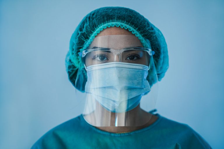 Portrait of young female nurse work inside hospital during coronavirus period - Woman medical worker on Covid-19 outbreak wearing face protective mask, COVID-19