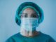 Portrait of young female nurse work inside hospital during coronavirus period - Woman medical worker on Covid-19 outbreak wearing face protective mask, COVID-19