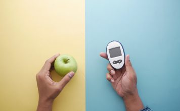 holding diabetic measurement tools, apple on table .