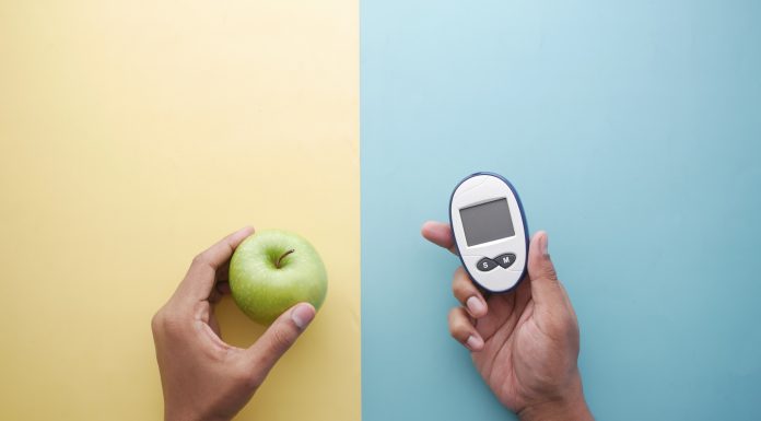 holding diabetic measurement tools, apple on table .